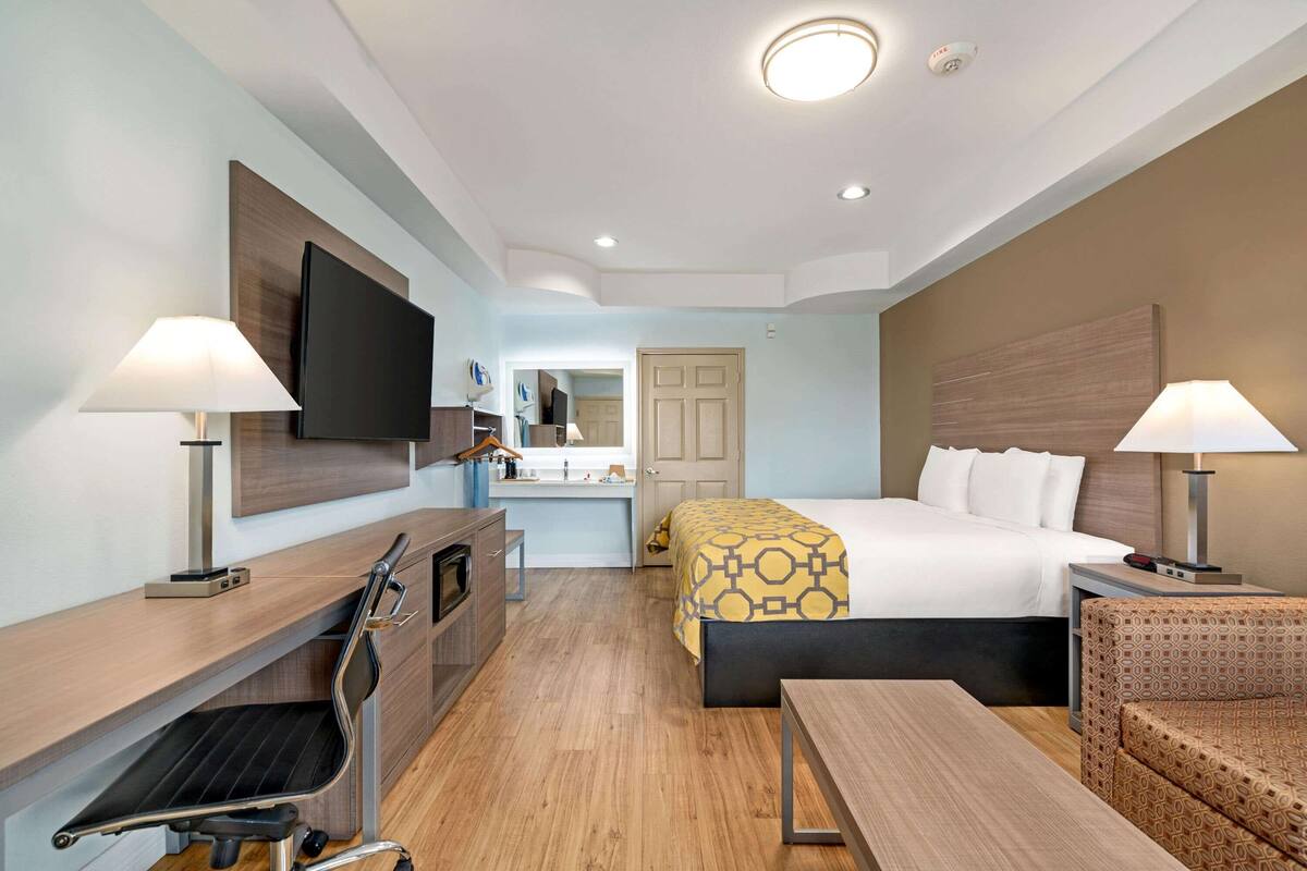 Een hotelkamer met een bed, bureau, stoel en een televisie.