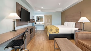 Une chambre d’hôtel équipée d’un lit, d’un bureau, d’une chaise et d’un téléviseur.