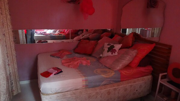 A bed with a mattress, pillows, and a blanket.