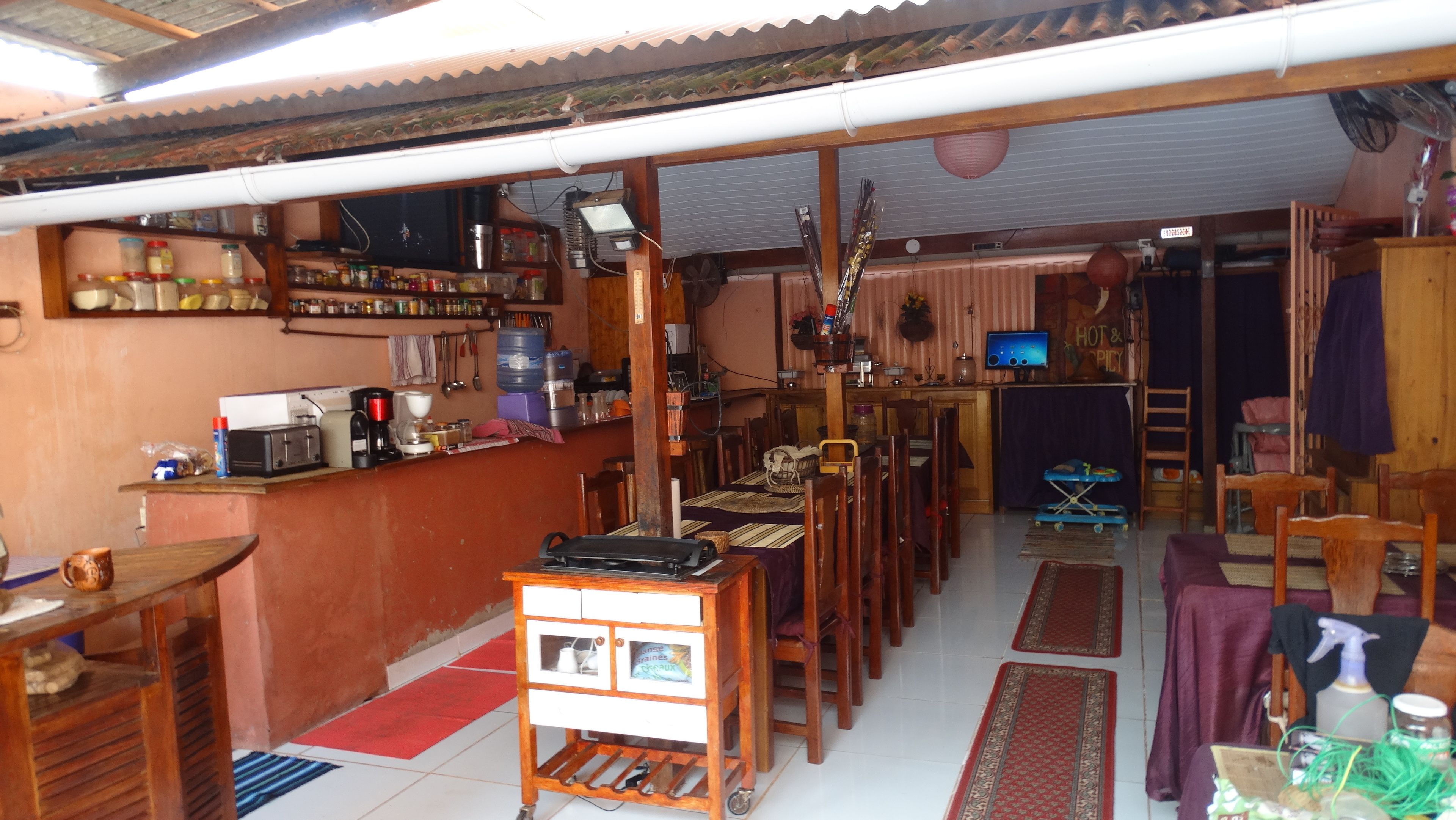 A compact living space with a kitchen area, dining table, and a small entertainment unit.