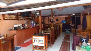 Un espacio habitable compacto con zona de cocina, mesa de comedor y mueble de entretenimiento pequeño.