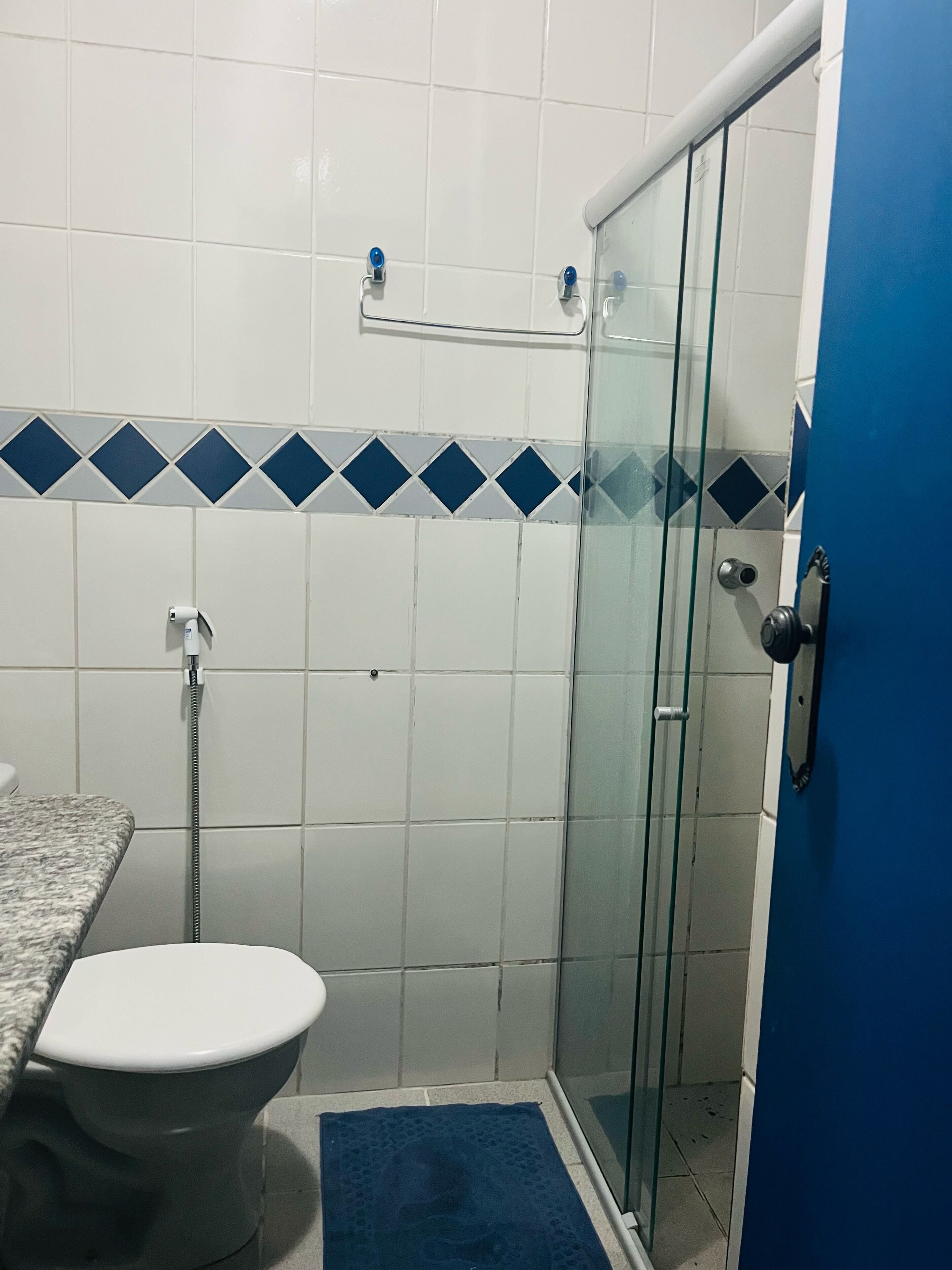 Un baño con cabina de ducha de vidrio, inodoro y lavabo.