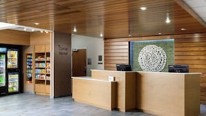 A reception desk with a wooden finish, a vending machine, and a display of snacks.