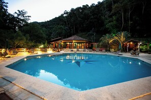 Alberca techada, alberca al aire libre y camastros