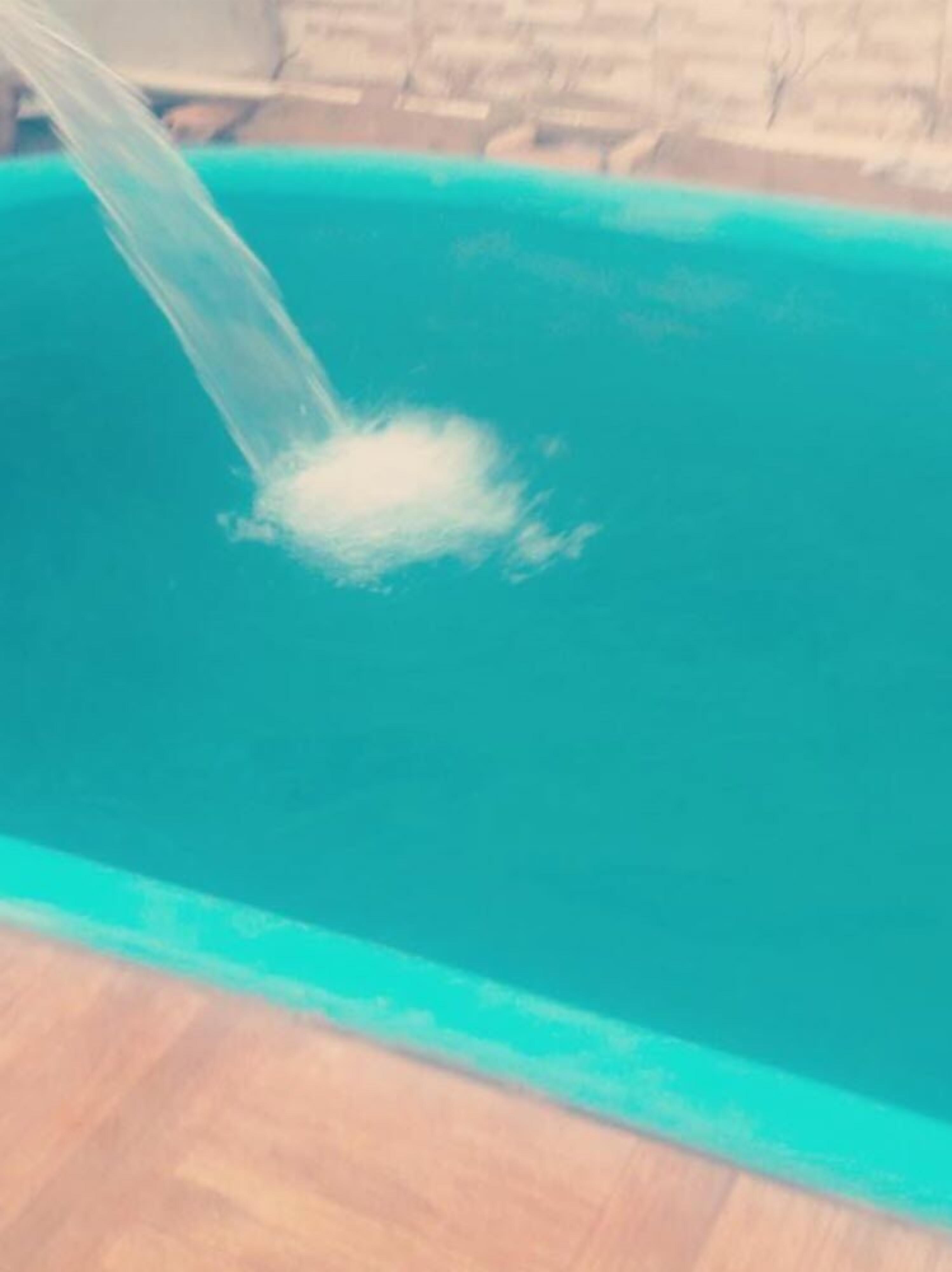 Una piscina con agua cristalina y un chapuzón visible.