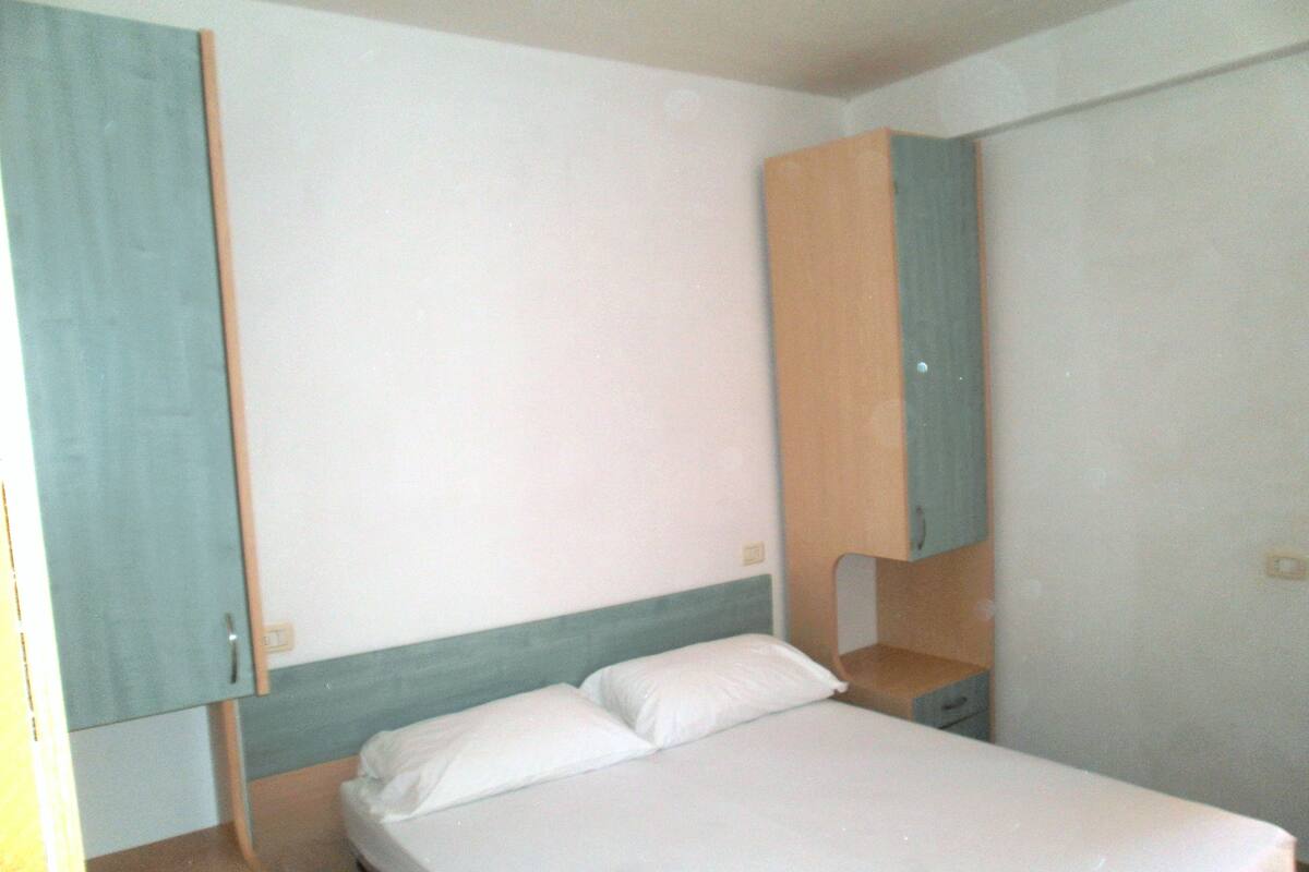 Escritorio, tabla de planchar con plancha y ropa de cama