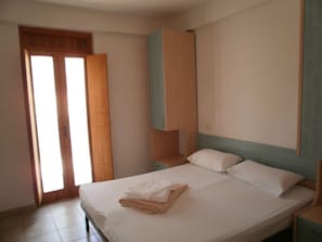 Escritorio, tabla de planchar con plancha y ropa de cama