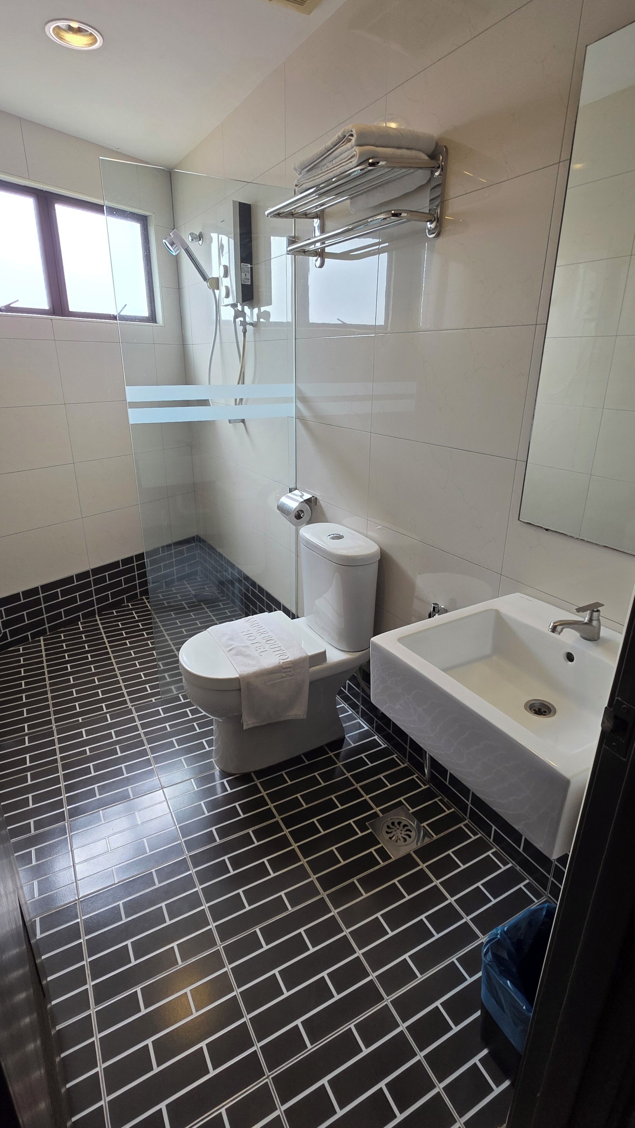 A bathroom with a toilet, sink, and shower area.