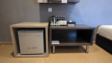 A compact kitchenette with a mini-fridge, a coffee maker, and a bottle of hand soap.