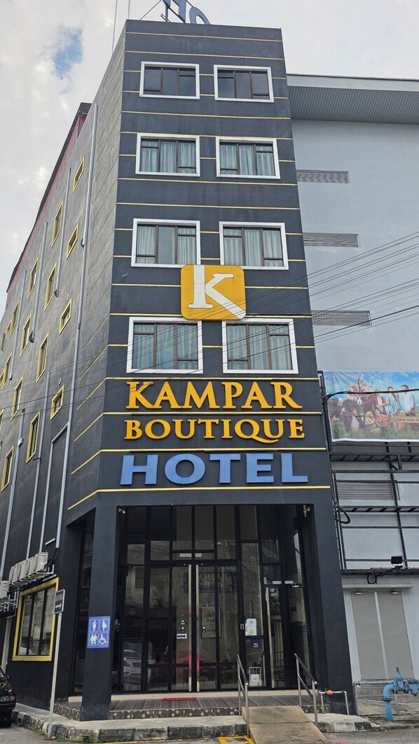 Un hotel con un letrero destacado que dice 'KAMPAR BOUTIQUE HOTEL' y un gran logotipo 'K'.