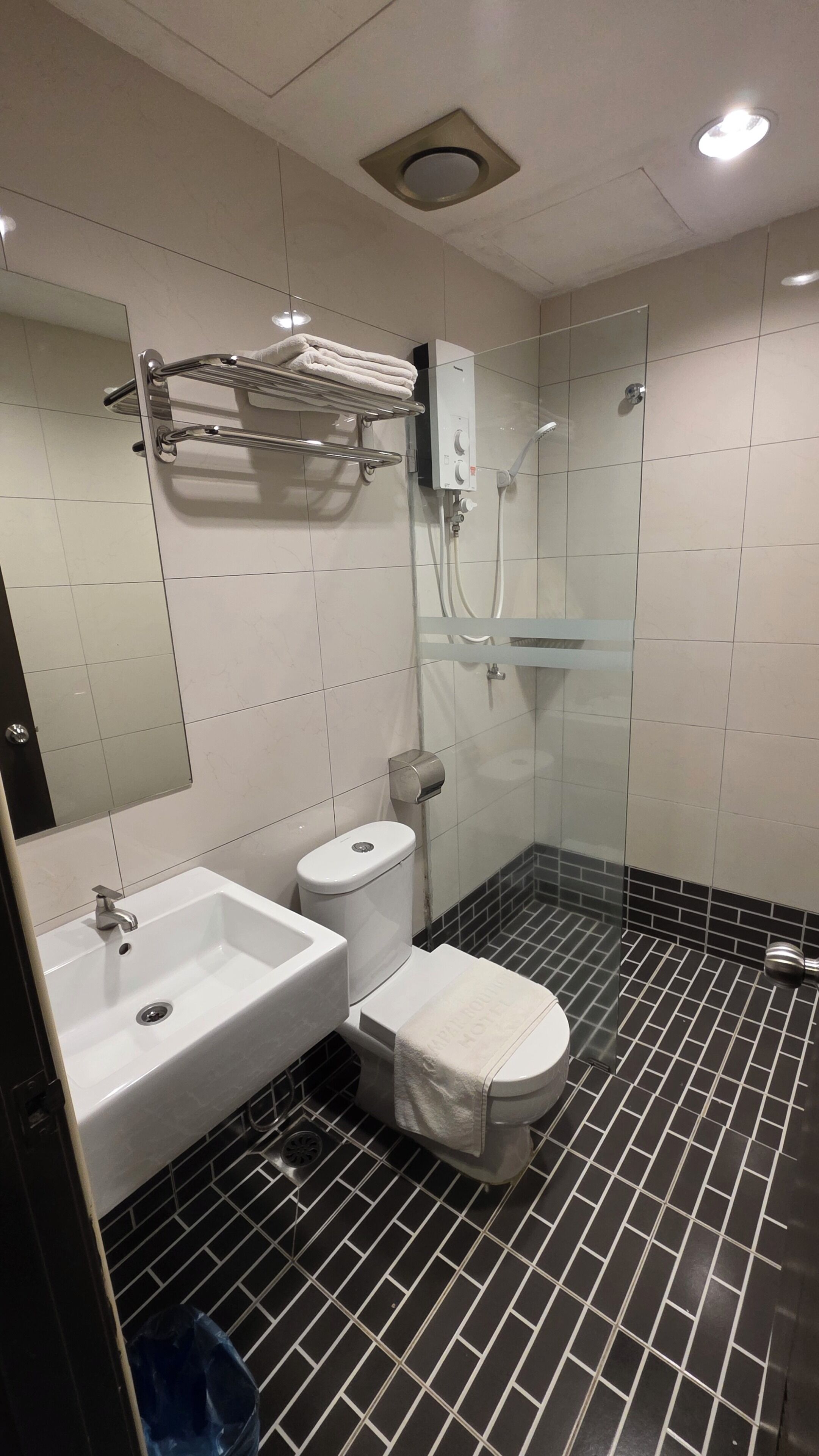 Uma casa de banho moderna com lavatório branco, sanita e cabine de duche em vidro.