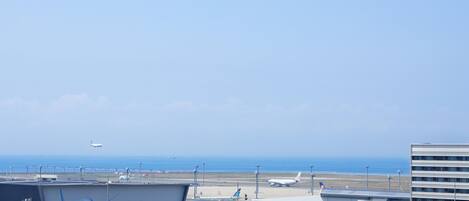 An airport with a large mural of an airplane, a runway, and a building with a modern design.