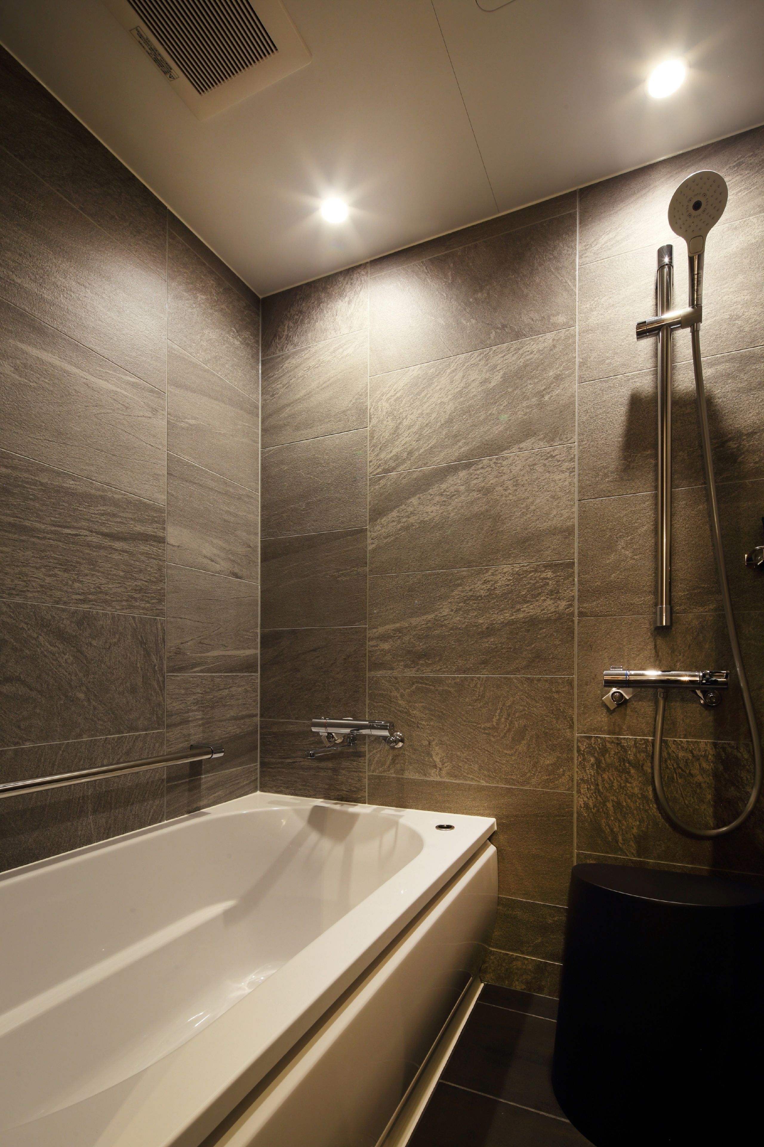 A modern bathroom with a freestanding bathtub, a showerhead, and a toilet.