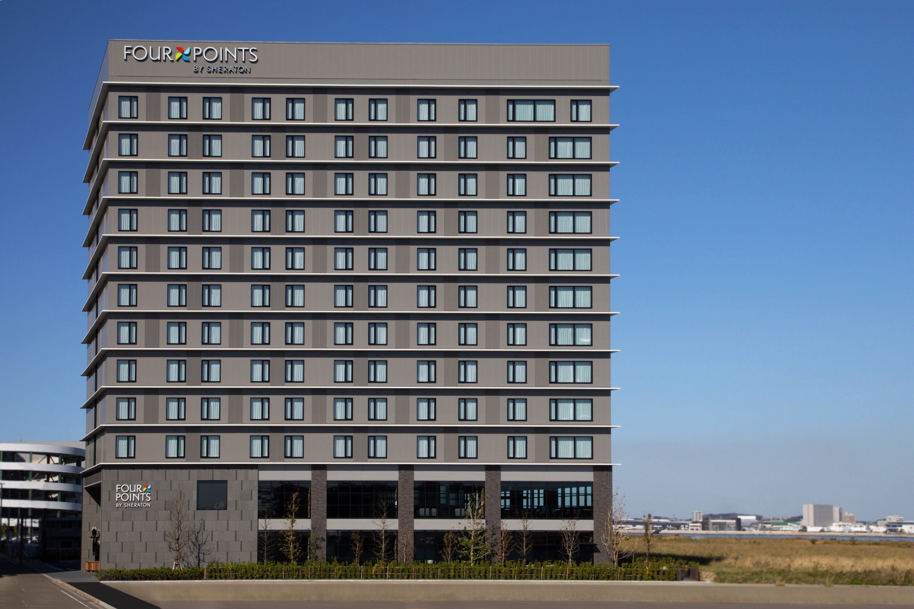 A multi-story hotel with a modern design, featuring a series of windows and a flat roof.