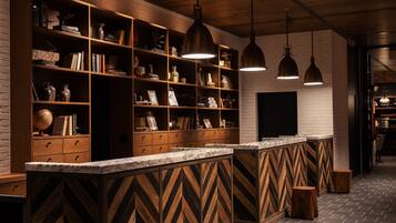 Un'area bar moderna con scaffali in legno, piani in marmo e illuminazione a sospensione.
