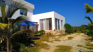 A modern white building with large windows and a covered outdoor area. - Casa del Mar (Santa María Tonameca)