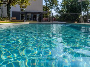 A clear swimming pool with a view of a building in the background. - ibis budget Le Cannet des Maures (Le Cannet-des-Maures)
