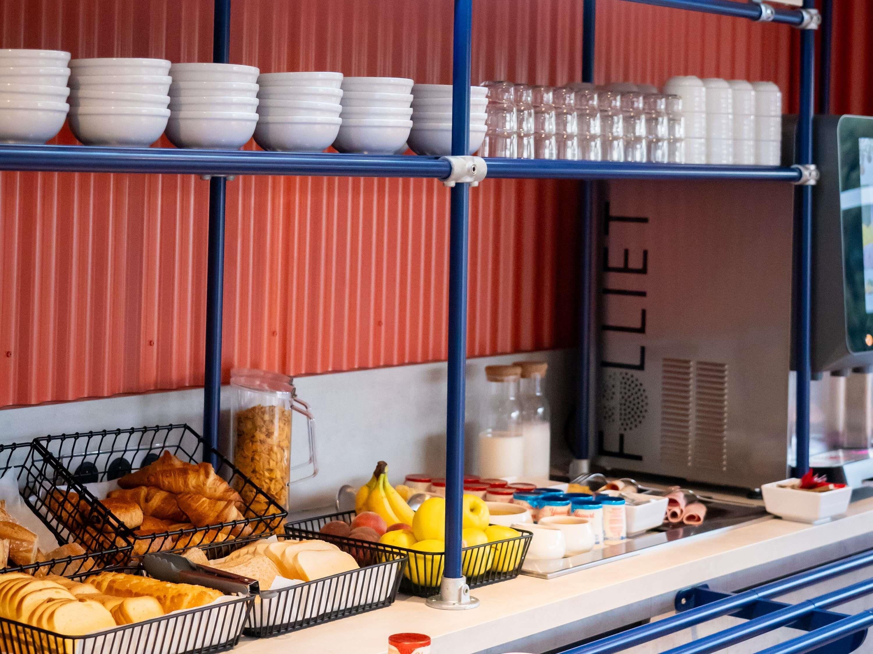 En morgenmadsbuffet med brød, kager, frugt og tilbehør.