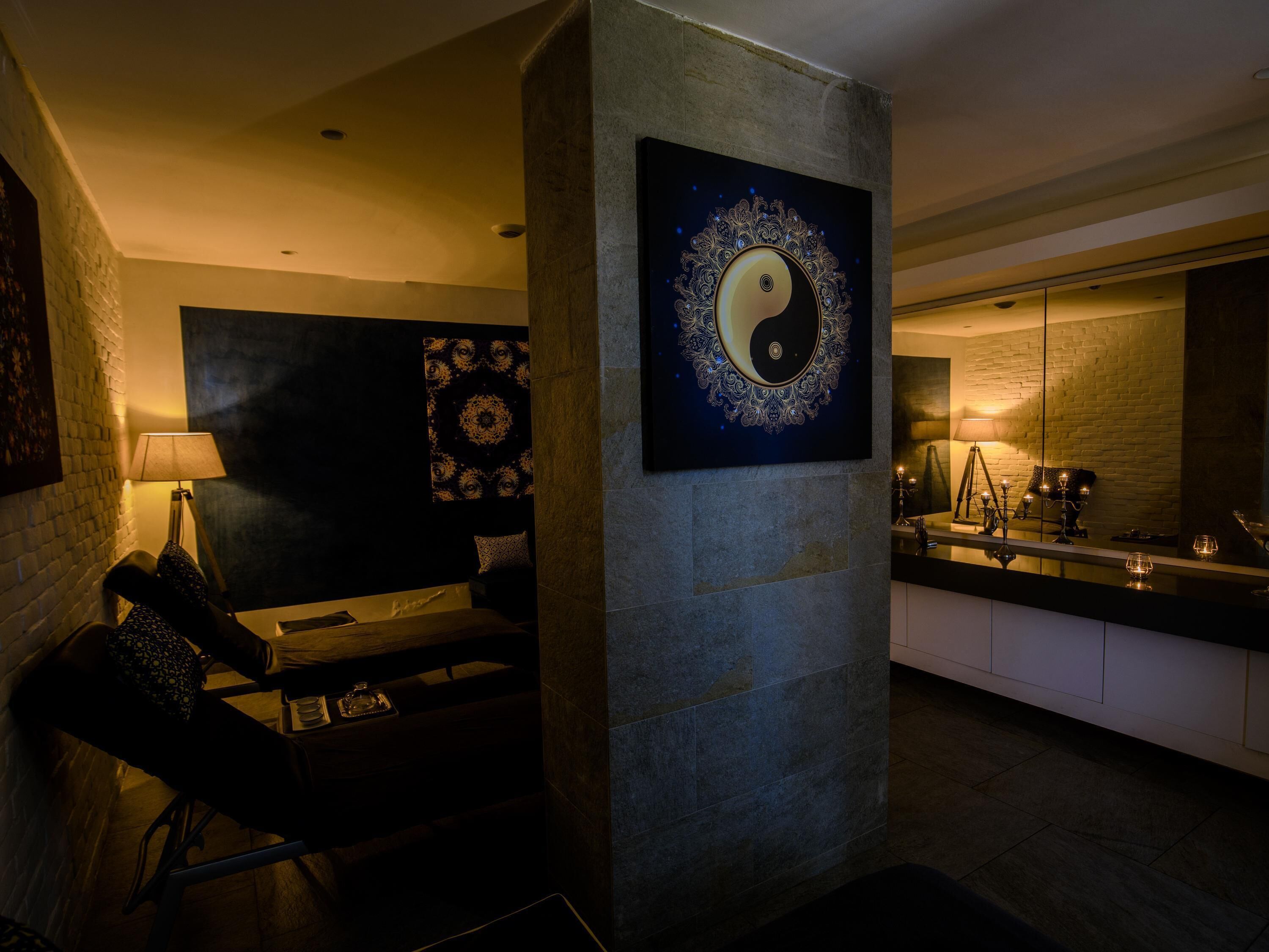 Un interior moderno con zona de comedor, un espejo grande y una obra de arte colgada en la pared.