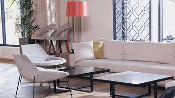 Un salon moderne avec un canapé, deux fauteuils et une table basse.