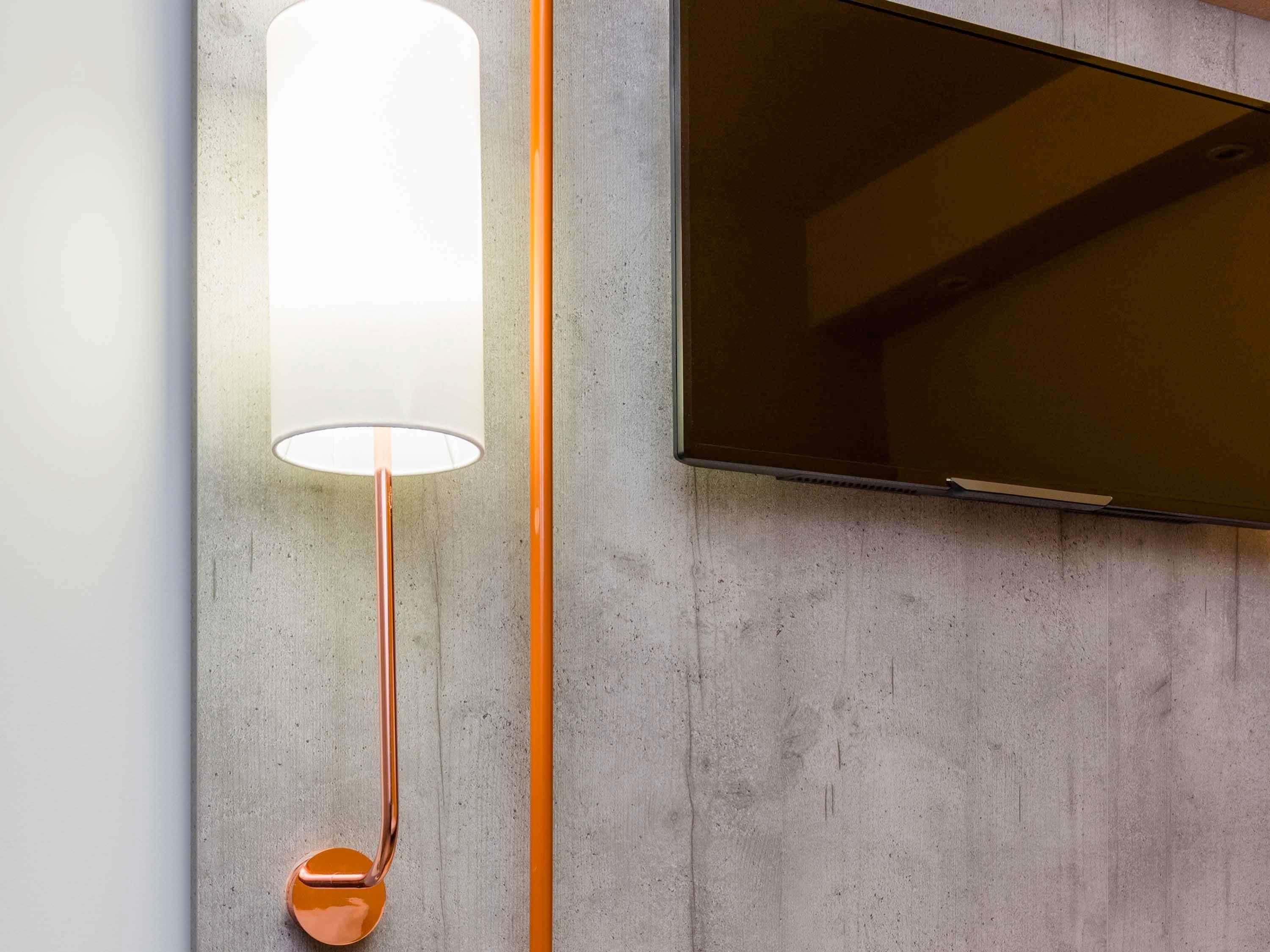 Un interno moderno con un lampadario a parete e un televisore a schermo piatto.