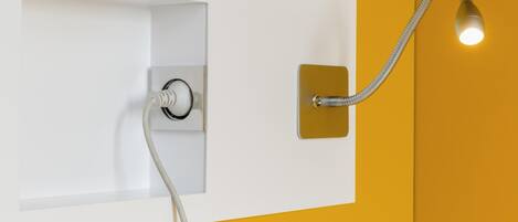 Une salle de bain avec un mur blanc, un mur d’accent jaune et une douche équipée d’un flexible.