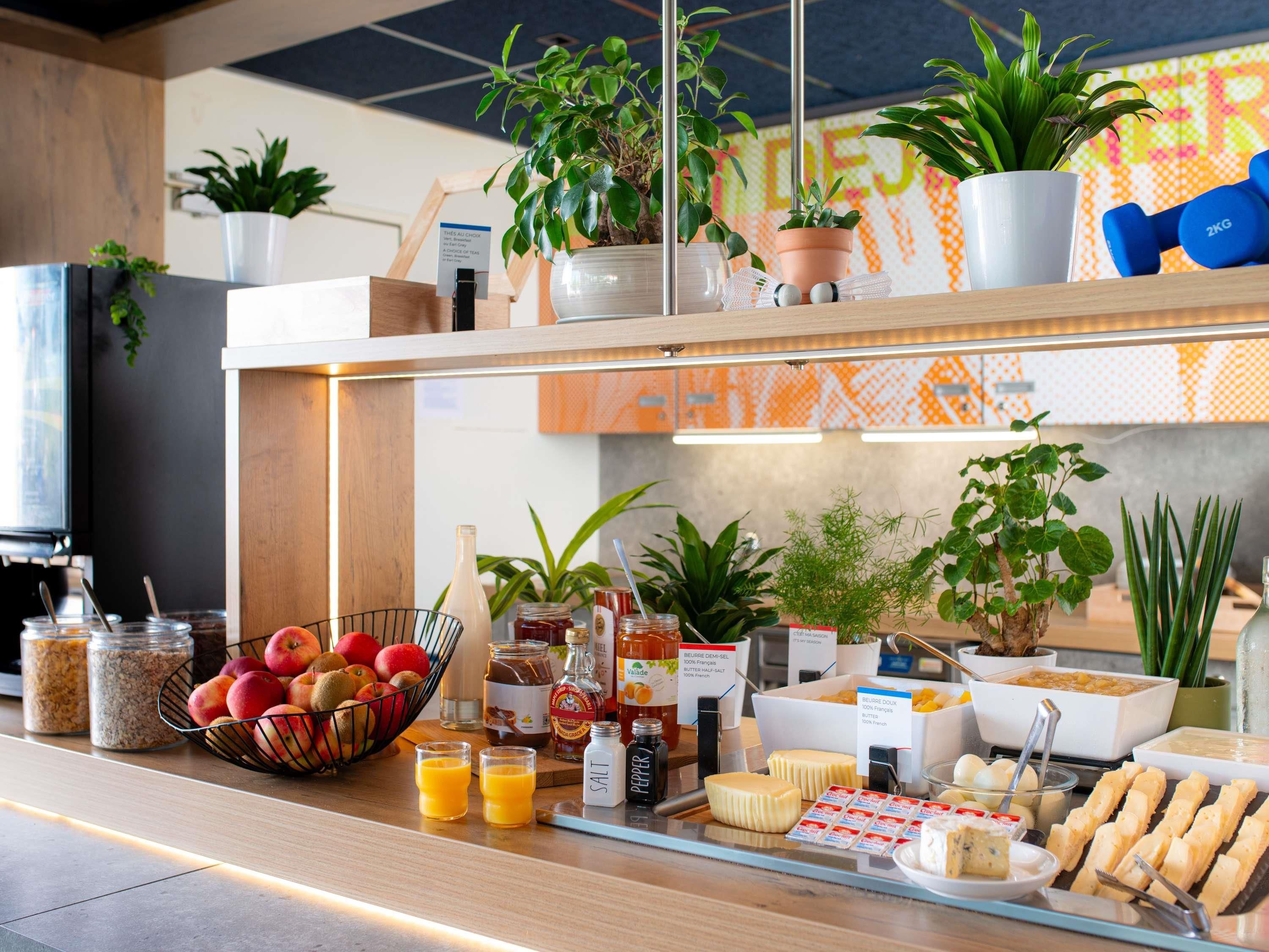 A breakfast buffet with fruits, beverages, condiments, and dairy products.