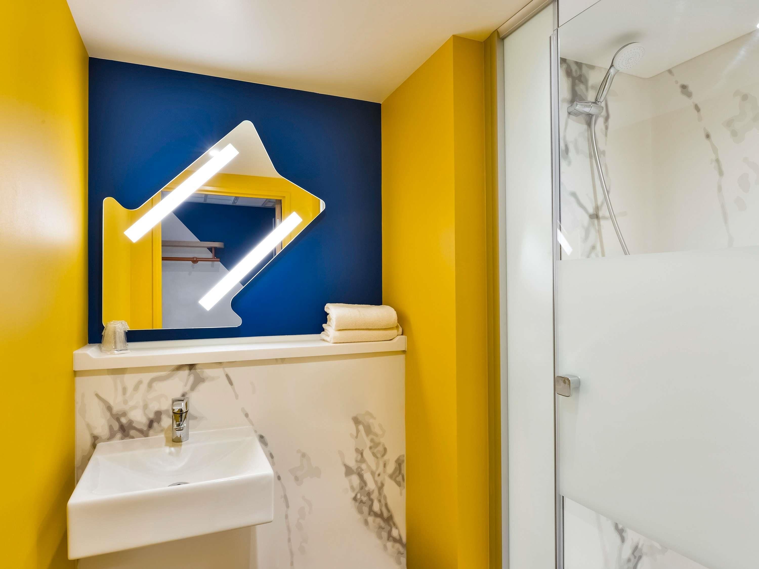 A bathroom with a sink, mirror, and shower.