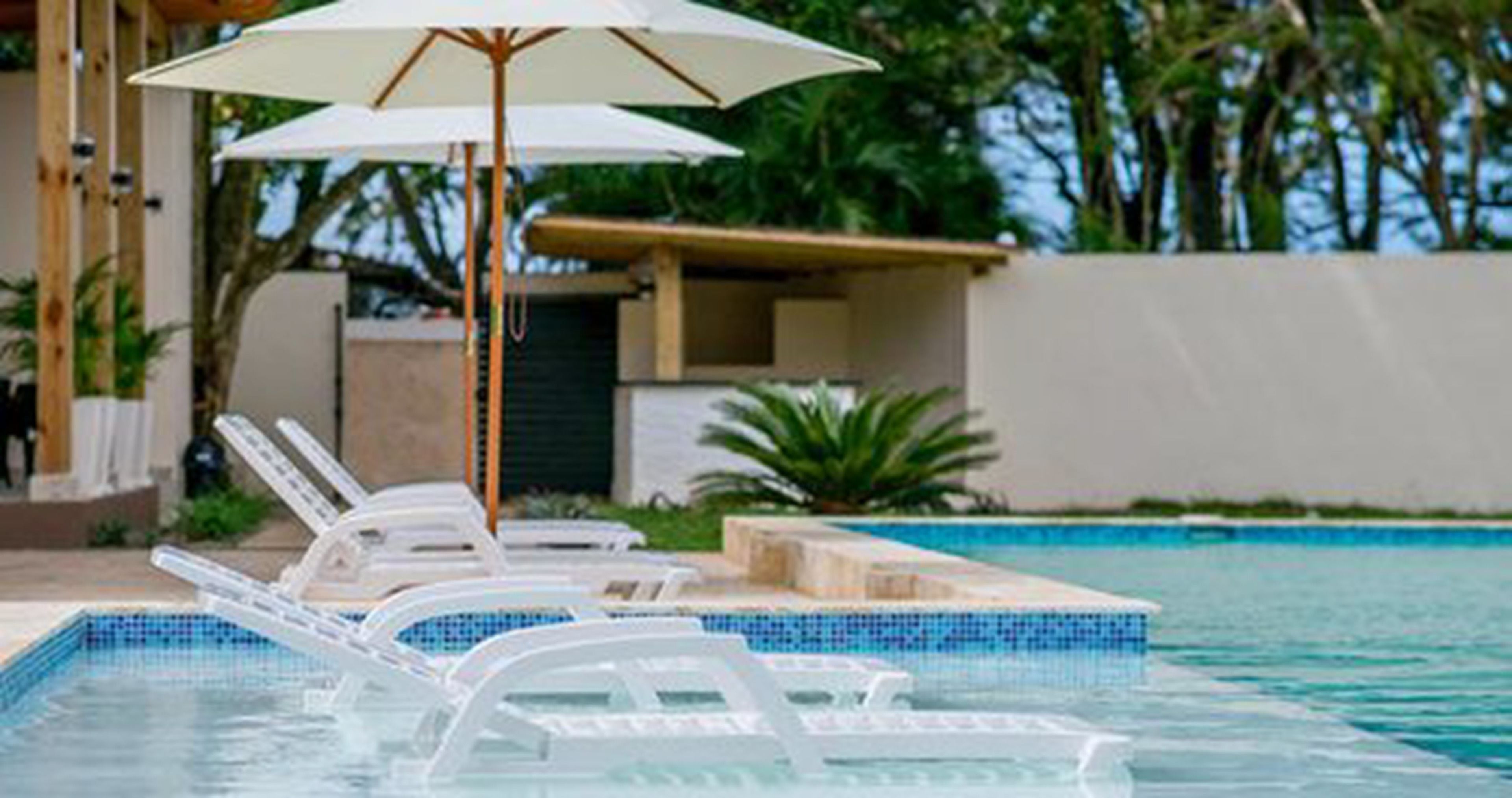 Piscina externa, guarda-sóis, espreguiçadeiras