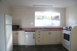 Aroha Kiwi Lodge | Private kitchen | Microwave, cookware/dishes/utensils