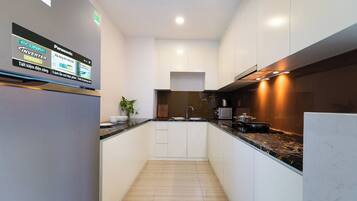 A modern kitchen with white cabinets, a black countertop, and a built-in stove.