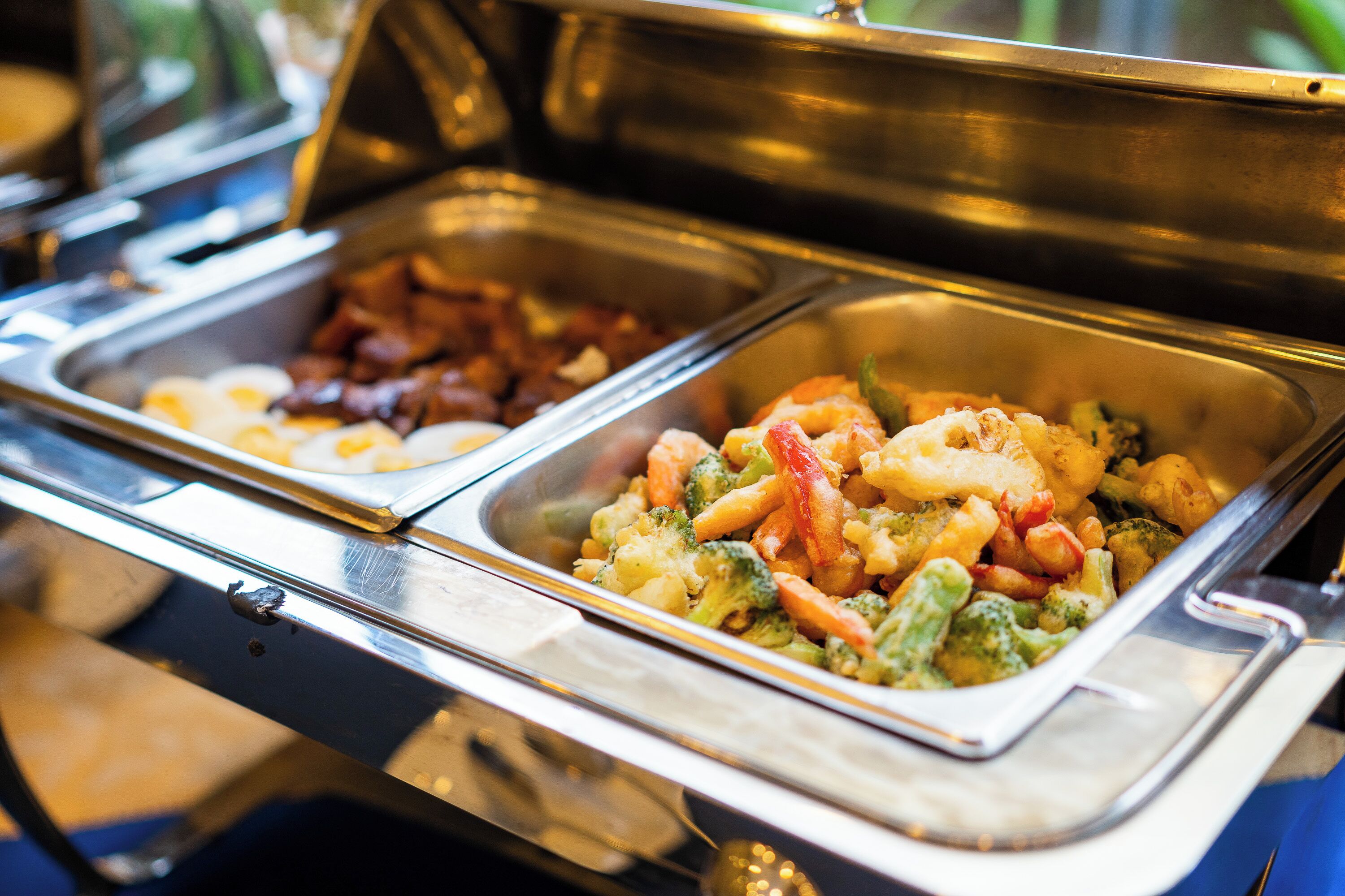 A buffet with various food options including pasta, vegetables, and meats.