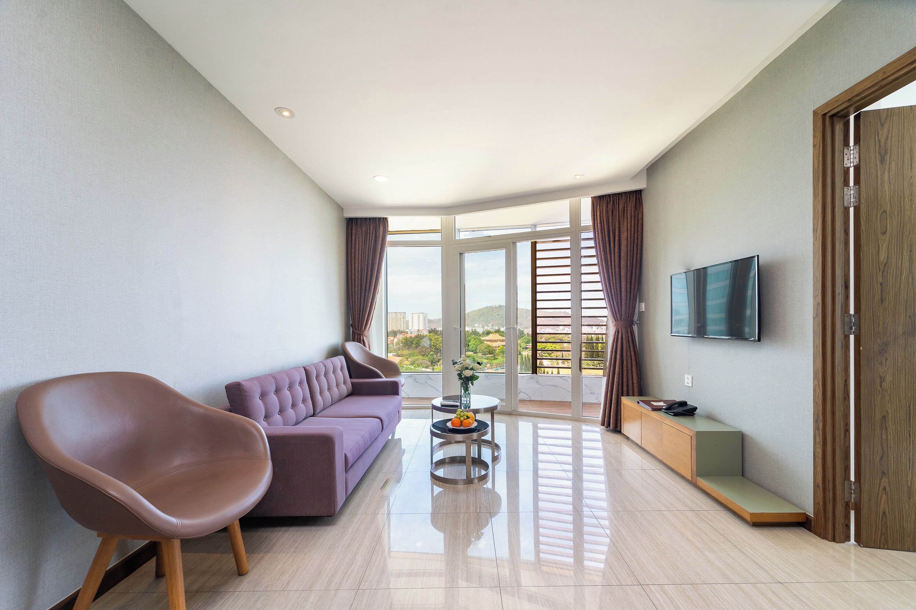 Una sala de estar moderna con un sofá, una silla, una mesa de centro y un televisor.