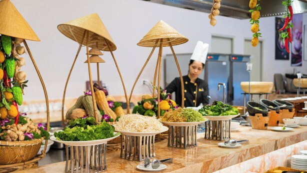 A buffet setup with various food items and utensils on a marble countertop. - DIC Star Landmark Vung Tau (Ho Chi Minh City)