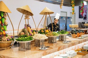 A buffet setup with various food items and utensils on a marble countertop. - DIC Star Landmark Vung Tau (Ho Chi Minh City)