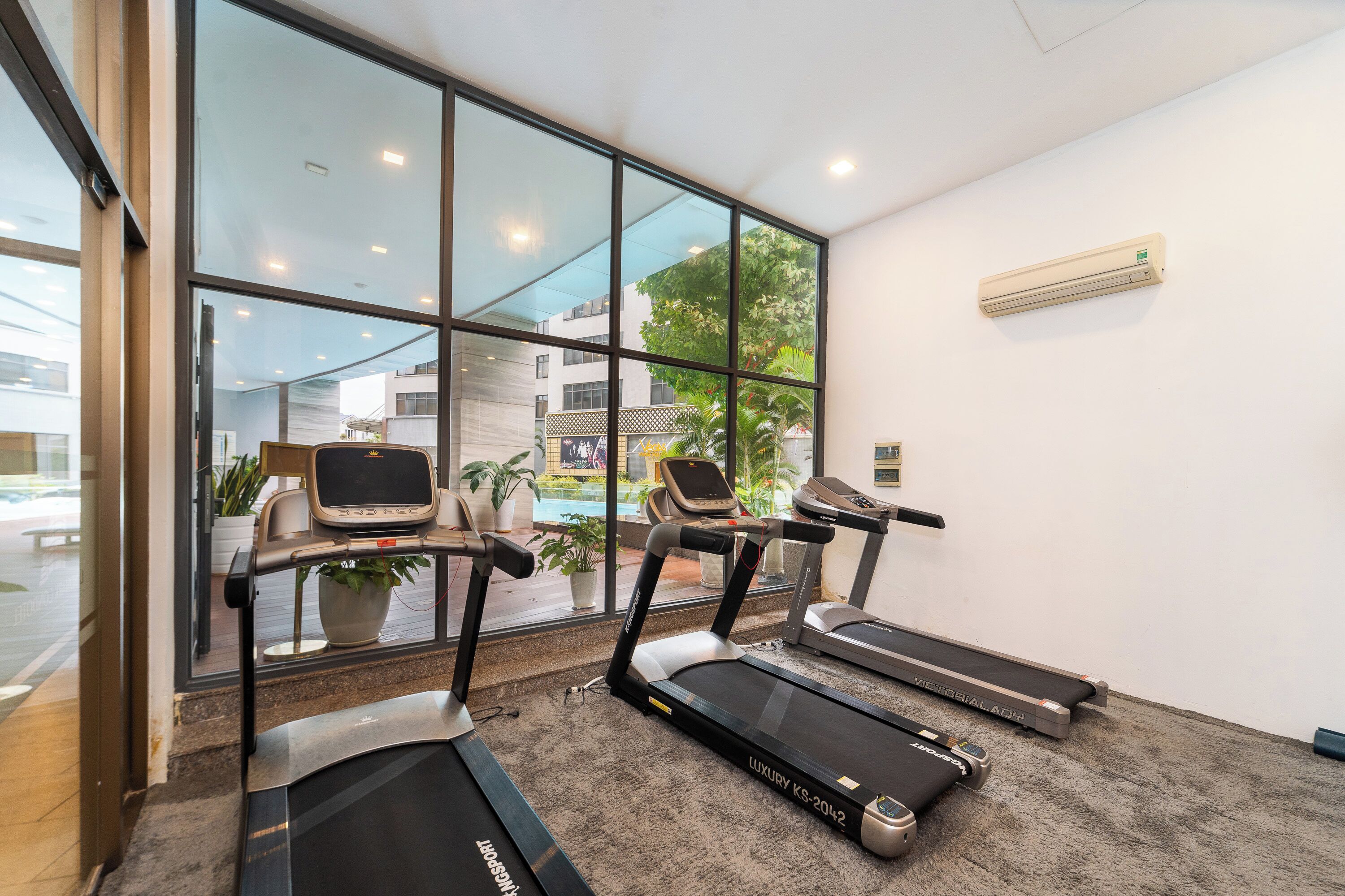 A gym with treadmills, a stationary bike, and a rowing machine.