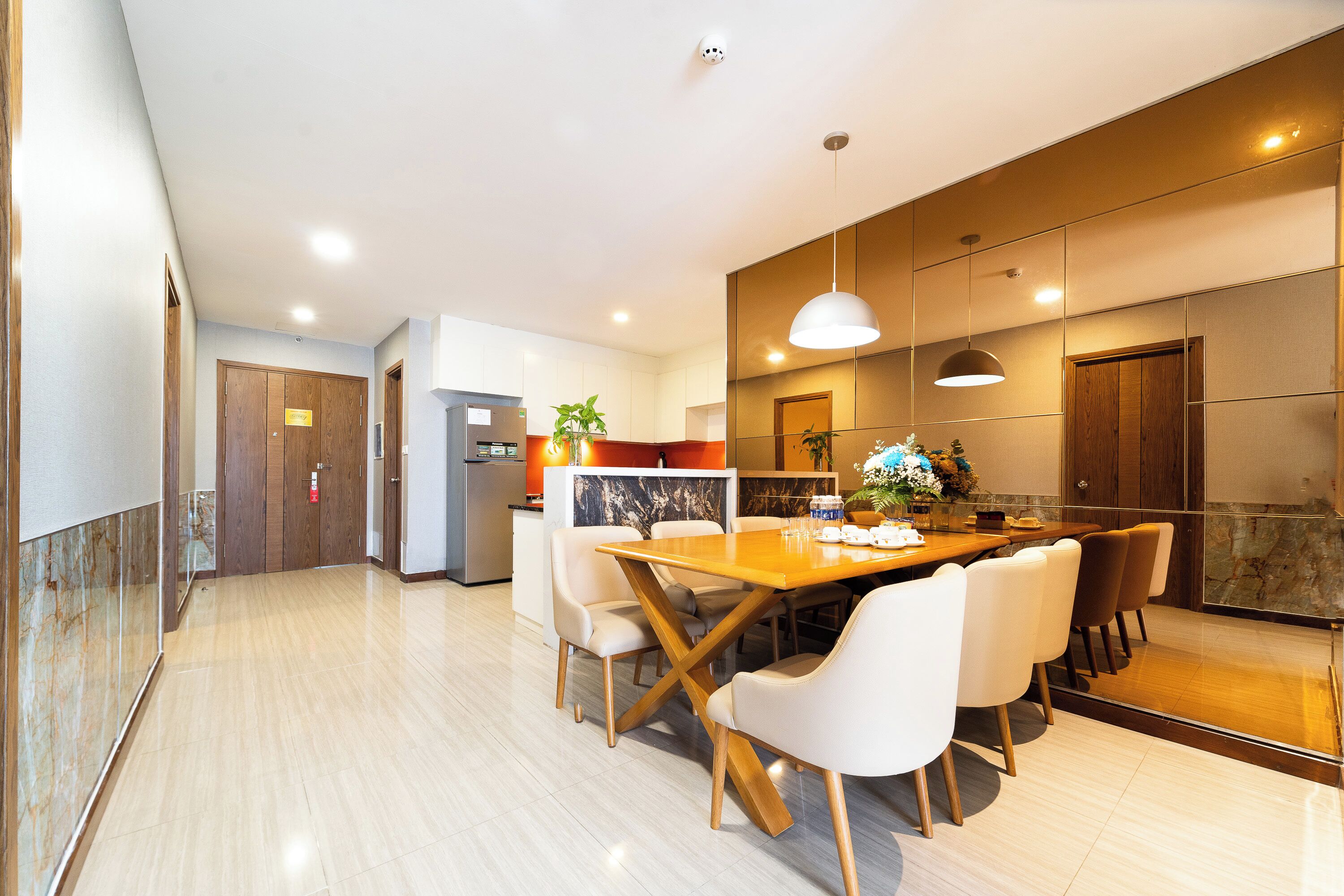 Una cocina moderna con comedor, que cuenta con una gran mesa de madera y sillas blancas.
