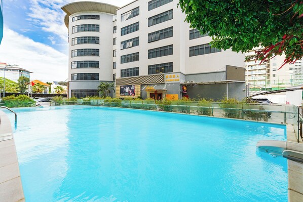 Una piscina al aire libre, sillones reclinables de piscina