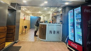 A reception area with a counter, a Coca-Cola refrigerator, and a chair. - New Basera Hotel (Ukhimath)