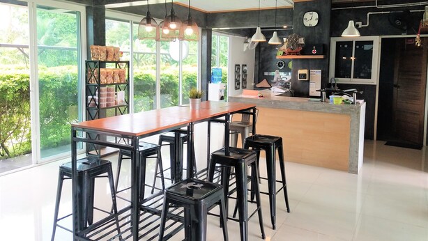 Een moderne keuken met een centraal kookeiland, barstoelen en hanglampen.