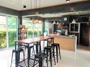 A modern kitchen with a central island, bar stools, and pendant lighting. - Loft Village Nakhon Nayok (Nakhon Nayok)