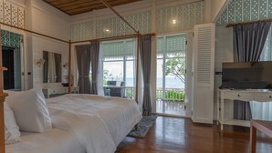 A bedroom with a large bed, a TV, and a balcony with a view of the sea. - De Chaochom Hua Hin (Hua Hin)