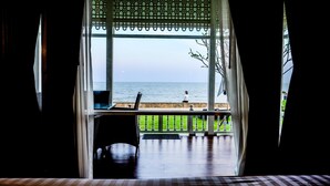 A room with a view of the sea, a chair, and a table. - De Chaochom Hua Hin (Hua Hin)
