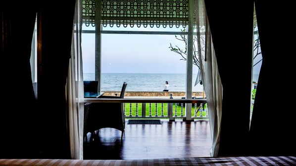 Una habitación con vista al mar, una silla y una mesa.