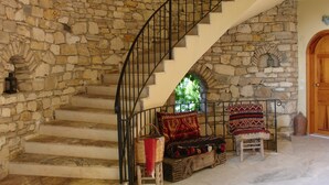 Una escalera de piedra con barandilla curva que lleva a una puerta de madera.