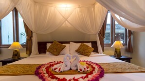 A hotel room with a bed, two lamps, and a decorative swan made of towels on the bed. - Niniku villa (Tegallalang)