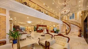A grand lobby with a marble floor, a grand staircase, and luxurious seating areas. - Eden Hotel (Da Nang)