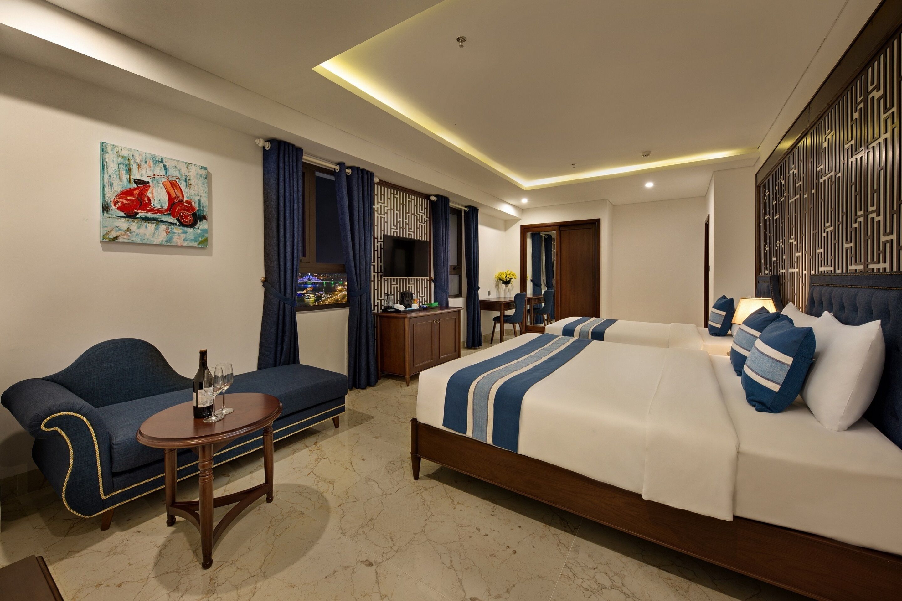Une chambre d’hôtel avec un lit, un canapé, une petite table et un téléviseur.