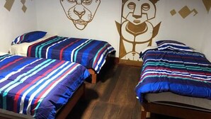 A room with two beds, each with striped bedding, wooden headboards, and a wall mural. - Déjà Vu Backpackers (Chachapoyas)