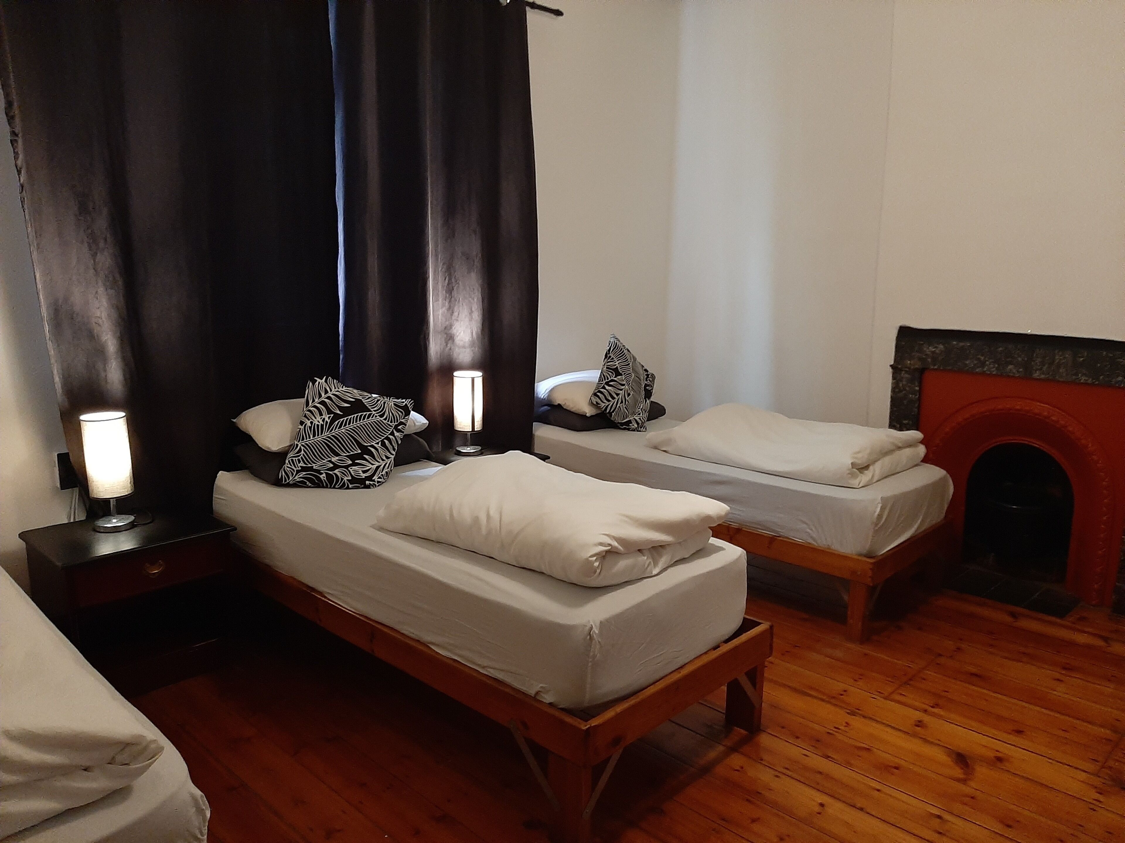 Habitación ((4 Single beds)) | Tabla de planchar con plancha y ropa de cama